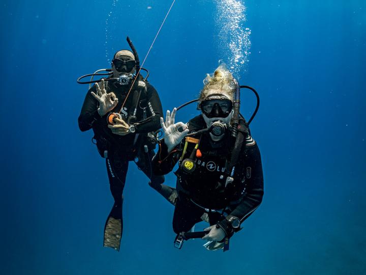 Two scuba divers posing for an underwater photo