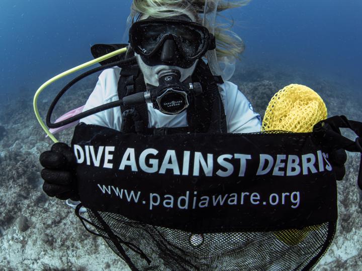 diver holding Dive Against Debris sign